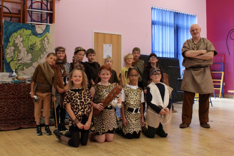 Children in their stone age costumes at Cedars Park with Dan from Portals to the Past